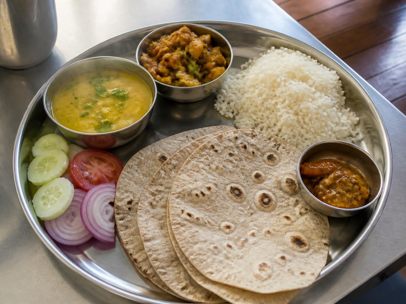 Home-style thali with rotis, dal, sabzi, rice, salad and achar